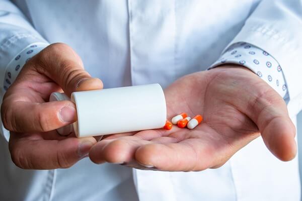 Man holding pills in his hands