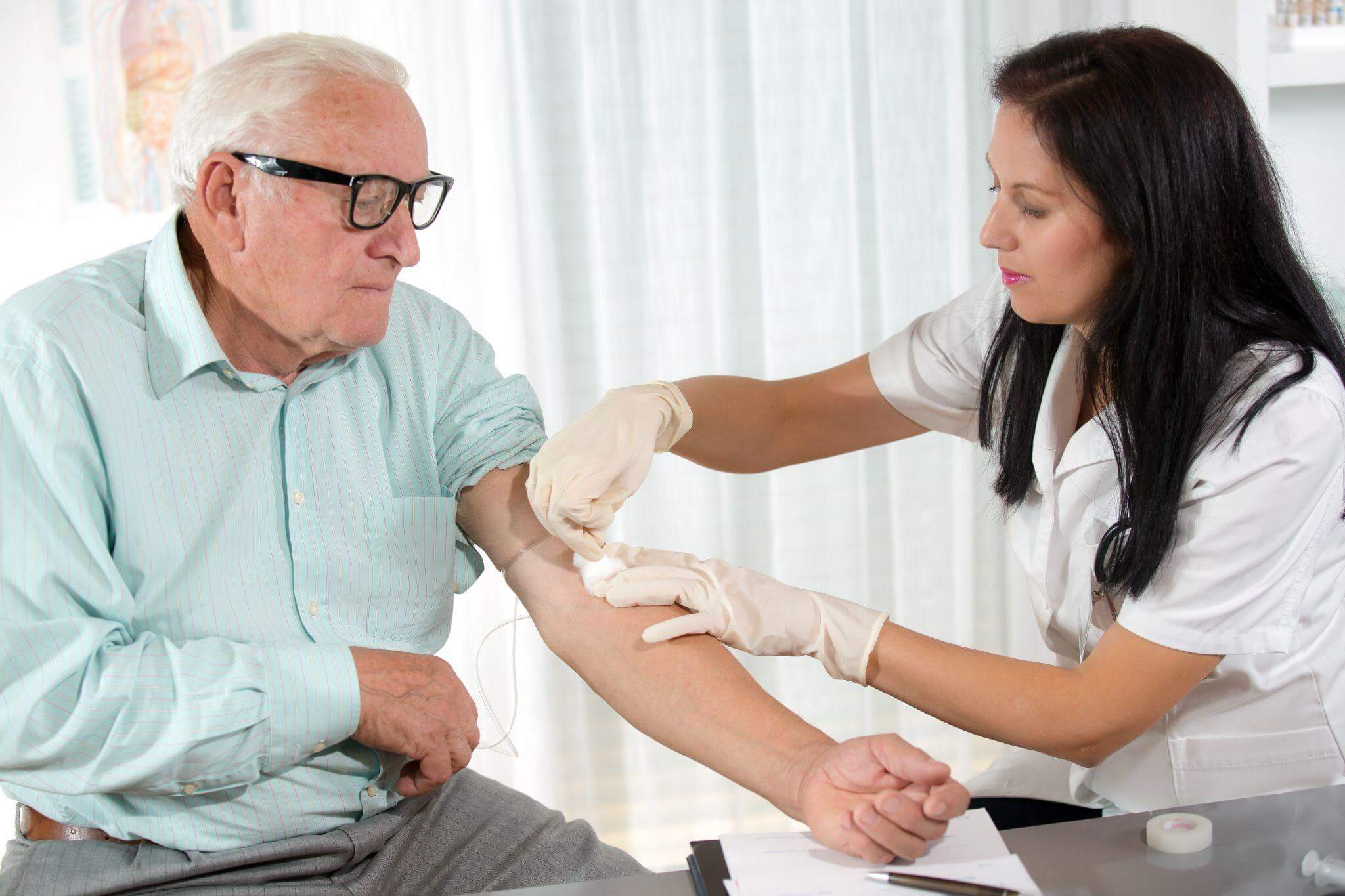 Nurse drawing blood from an older man