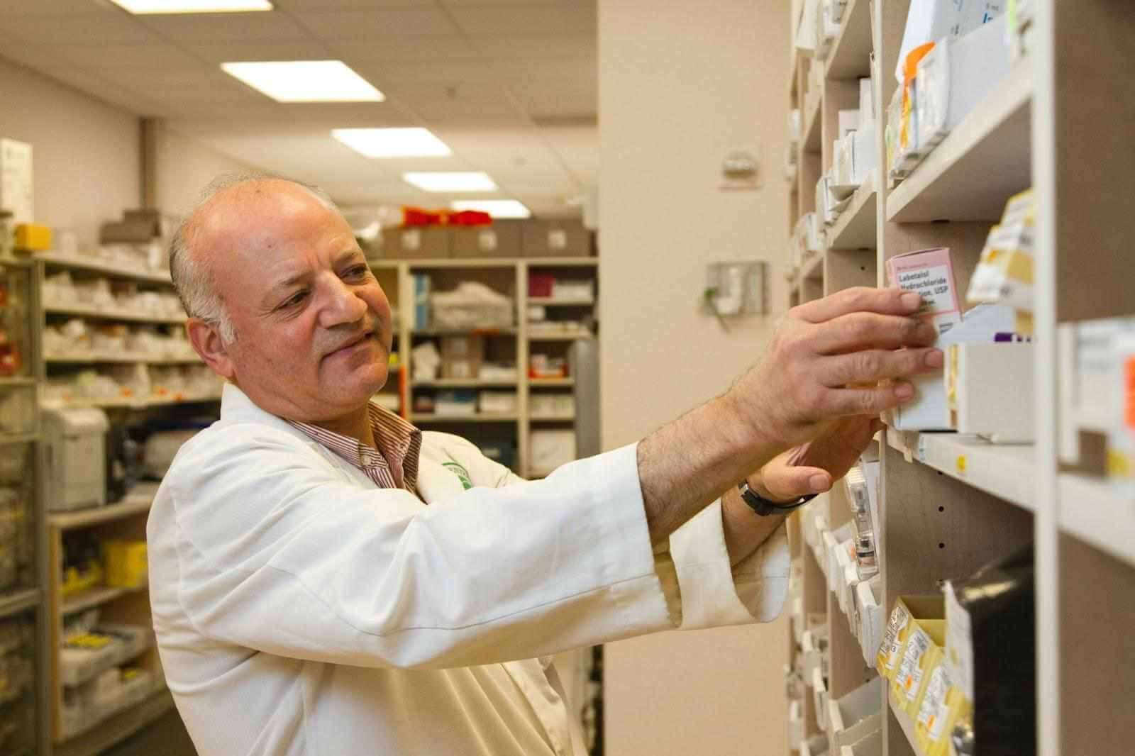pharmacist getting medicine off the shelves